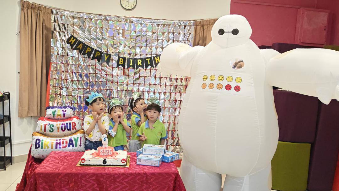 Children celebrating a birthday with a Baymax character at Dloving