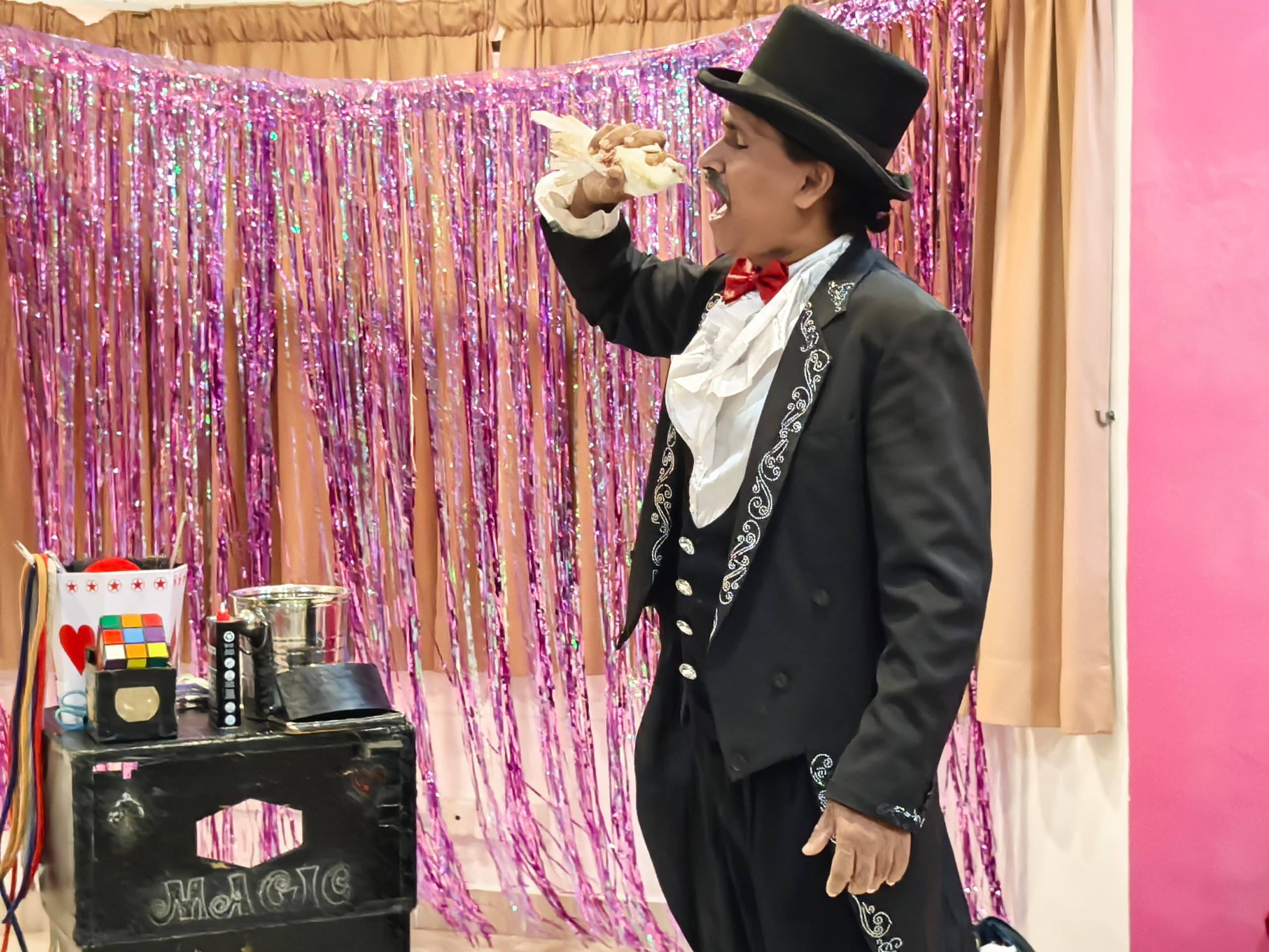 A magician entertaining children during a birthday celebration at Dloving