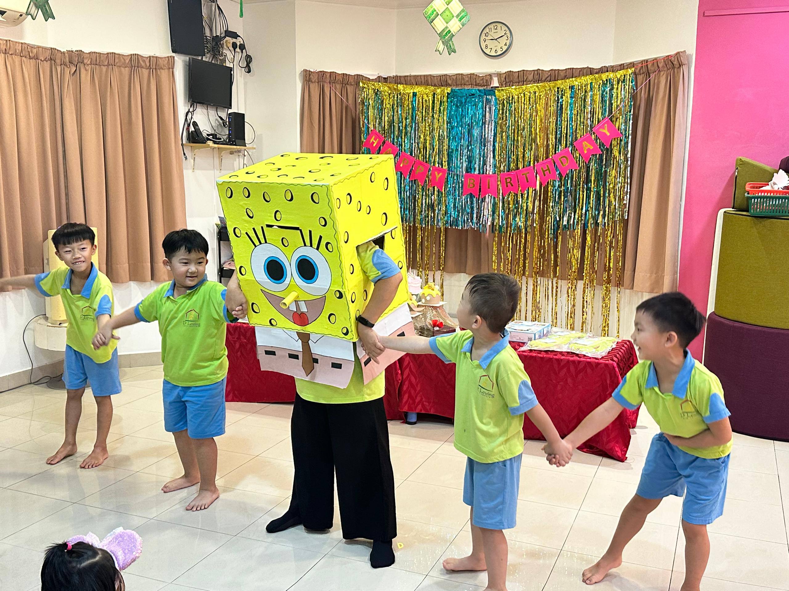 Children dancing with a SpongeBob character during a Dloving birthday party