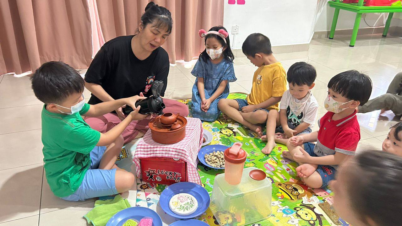 Children taking part in a hands-on cultural activity with a member of the D Loving Care and Learning Team