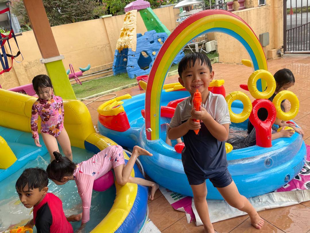 Children laughing and playing together during a water activity