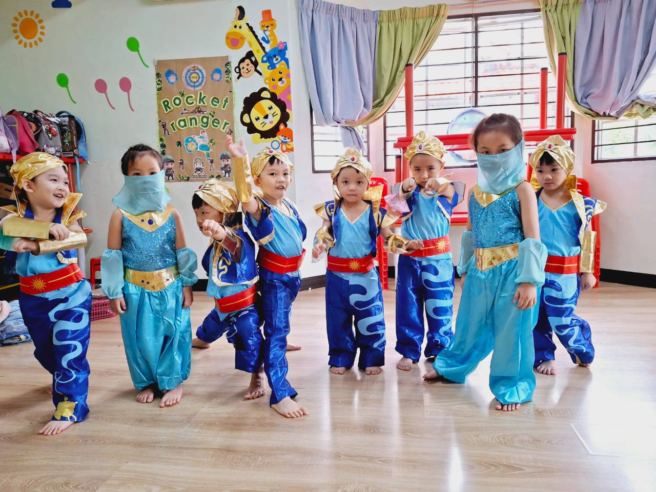 Young children in blue and gold costumes preparing for a Dloving performance